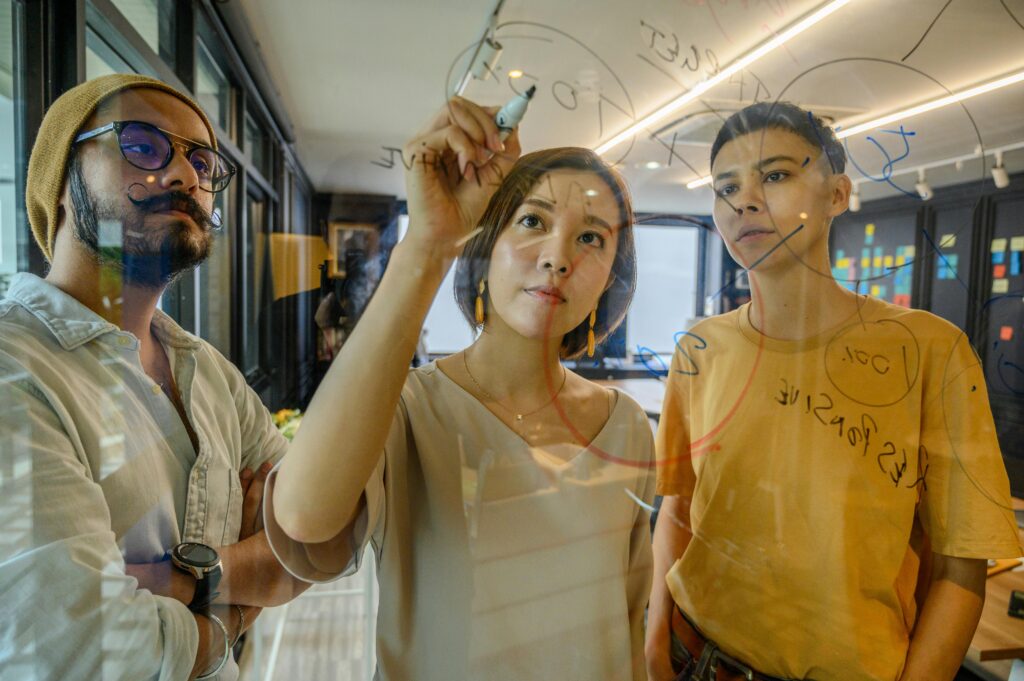 team writing ideas on a transparent wall