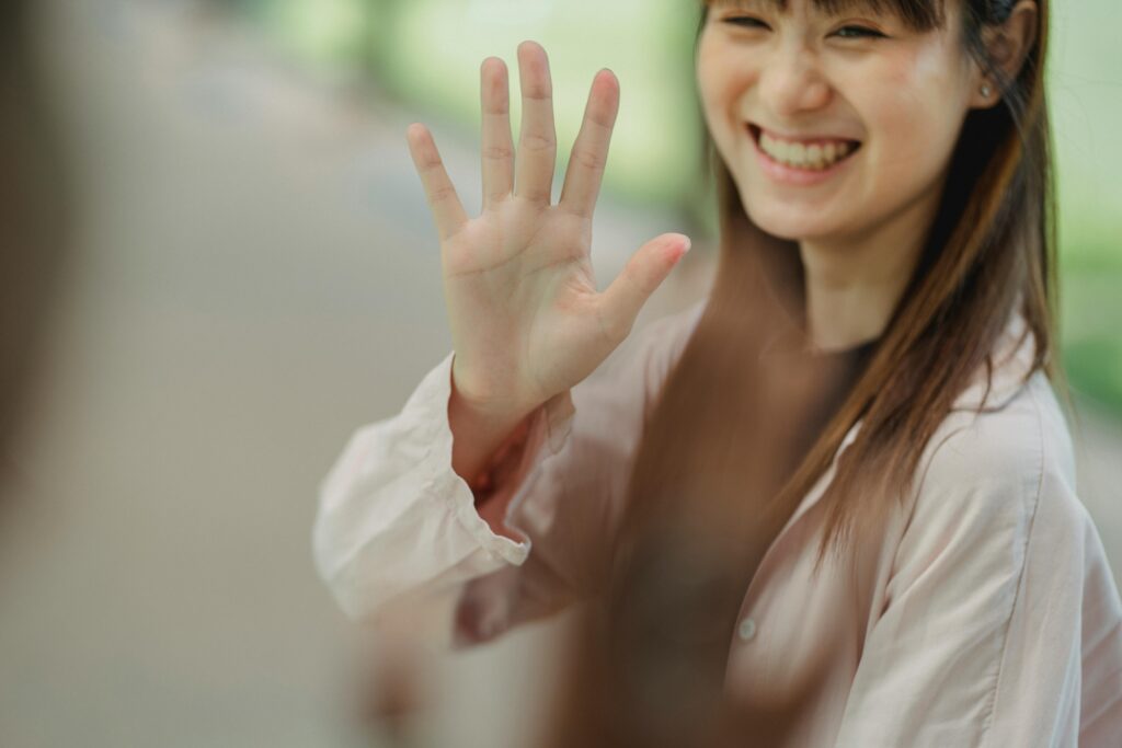 Asian woman waving goodbye