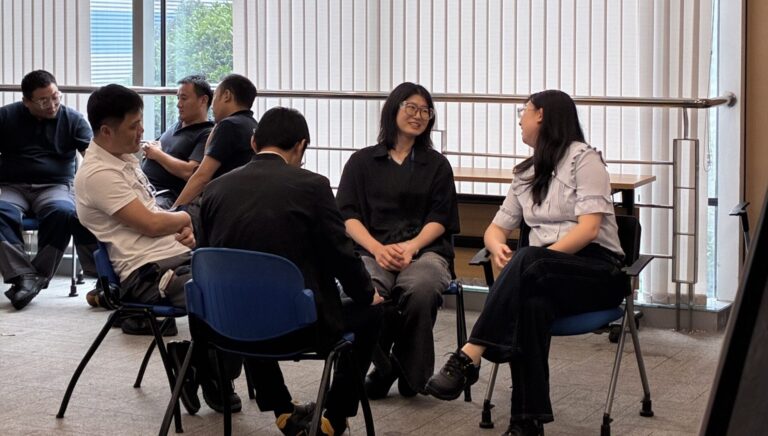 Team members during a coaching session, working through a communication exercise together.